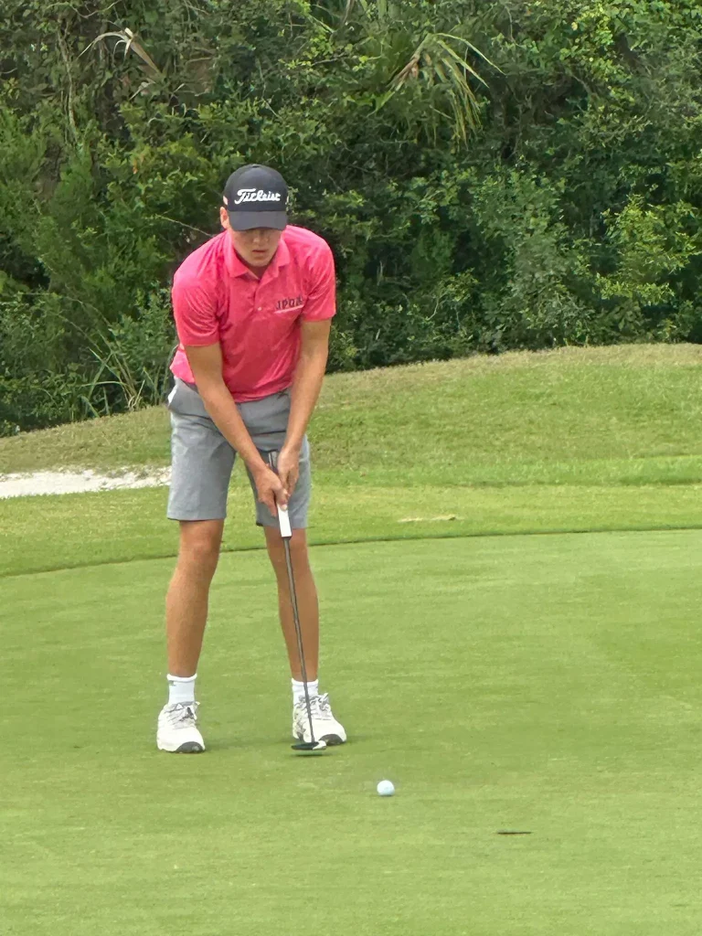 A JPGA player lining up a putt on the green